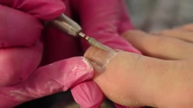 Usta, istemciye donanım pedikürü yapar. 