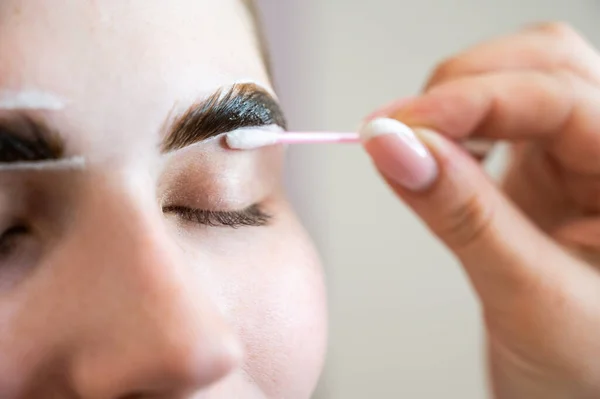 El maestro pinta las cejas de una mujer. — Foto de Stock