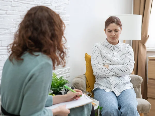 Bezorgde blanke vrouw tijdens een sessie met een psychotherapeut. — Stockfoto