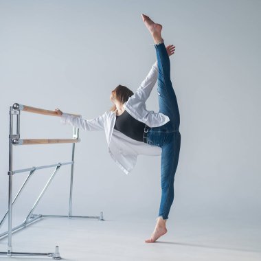 Gündelik giysiler içindeki beyaz kadın, bale barında yarığı çekiyor.. 