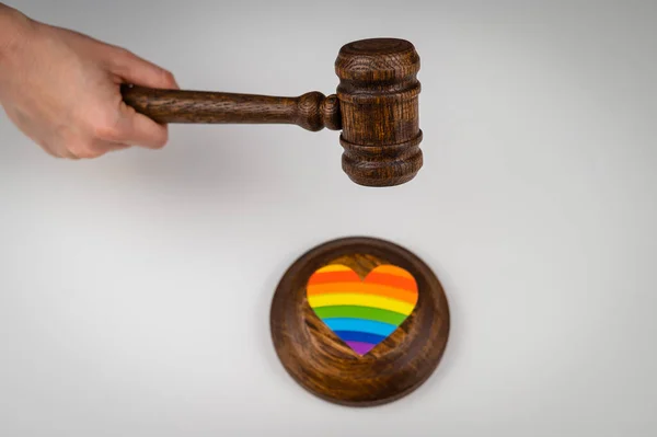 O juiz bate em um coração com uma bandeira do arco-íris com um martelo. — Fotografia de Stock