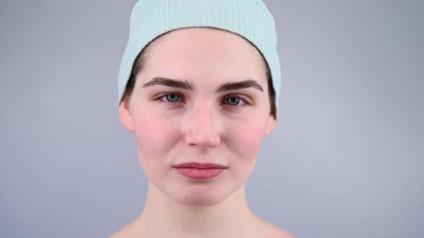 Close-up portret van een jonge vrouw masseren haar gezicht met een gouache scraper. — Stockvideo