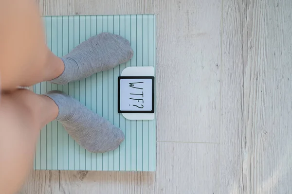Вид зверху на жіночі ноги в сірих шкарпетках на електронних масштабах. Дуже важка вага. Несподіване збільшення кілограмів на дієті. Питання в тому, що за хуй . — стокове фото