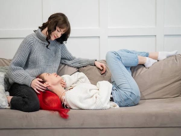 Junge Mädchen, die sich auf der Couch umarmen. Unisexuelle Liebe. — Stockfoto