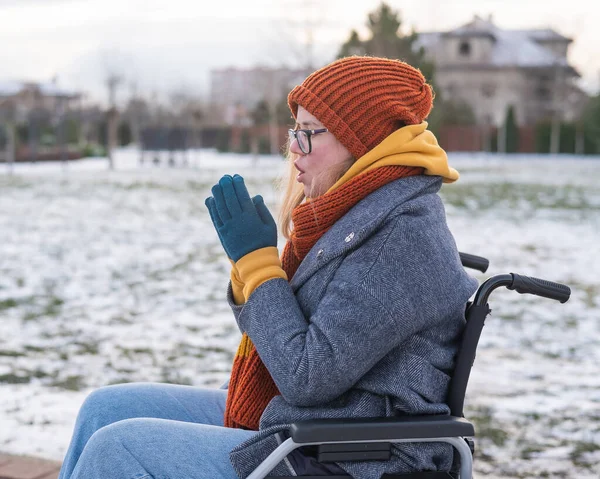 Blanke vrouw bevriest in een rolstoel in de winter. — Stockfoto