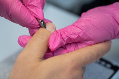 Manikürcü, erkek müşterinin tırnak etlerini meme uçlarıyla keser.. 