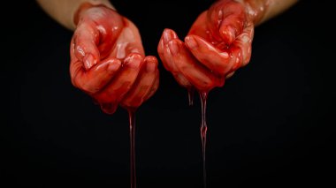 Kadınların elleri kana benzer kırmızı bir sıvının içinde..