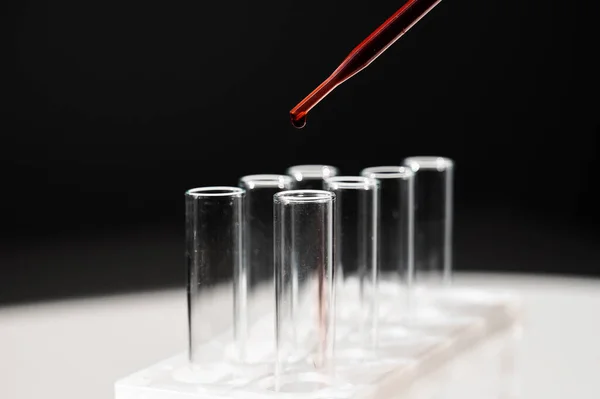 Close-up of a laboratory assistant dripping blood from a pipette into a test tube. Stock Photo