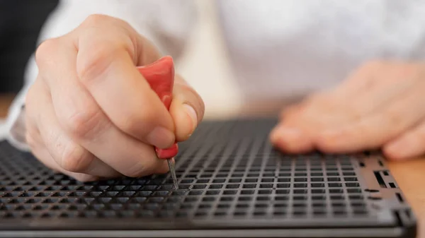 Una mujer usa una plantilla especial y un lápiz para escribir una carta en braille. — Foto de Stock