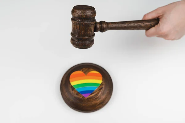 De rechter slaat een hart met een regenboogvlag met een hamer. — Stockfoto