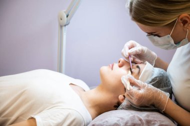 Kadınları tarama ustası kirpikleri kaplama öncesi hazırlıyor