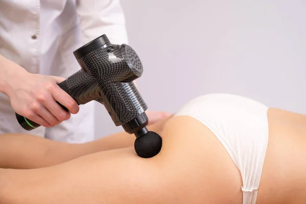 Médico Massageia Coxa Paciente Com Massageador Elétrico Com Uma Arma — Fotografia de Stock