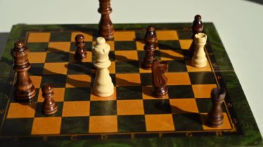 Bir adam papazı dönen satranç tahtasına düşürür. Yavaş çekim
