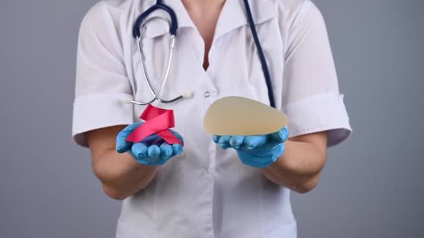 Mammolog Silikon Bir Göğüs Implantı Tutuyor Elini Pembe Bir Kurdeleyle — Stok video