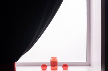 Pencere pervazında üç boş cam kırmızı vazo.