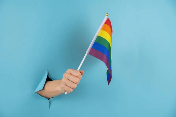 Womans Hand Sticks Out Hole Blue Paper Background Holds Lgbt — Stock Photo, Image