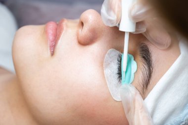 Kirpik boyama ve kaplama prosedüründen geçen genç bir kadın.