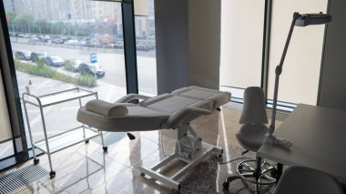 Beyaz kanepesi ve panoramik pencereleri olan boş bir güzellik salonu.