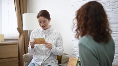 Psikolog bir hastayla seansta metaforik kartlar kullanıyor. Beyaz kadın derneklere anlatıyor