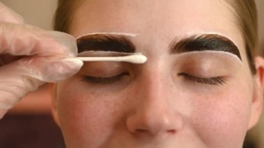 Usta bir kadının kaşlarını boyuyor.