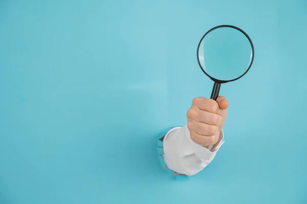 Eine Frauenhand Die Aus Einem Loch Einem Papierblauen Hintergrund Ragt — Stockfoto