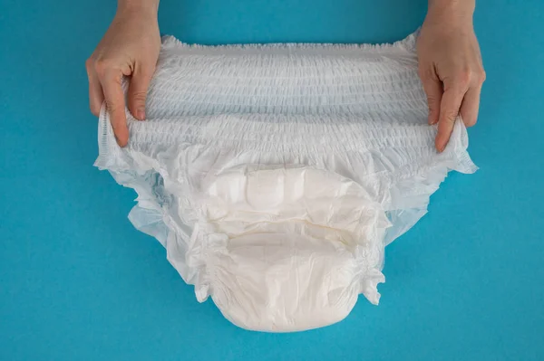 Eine Frau Hält Eine Erwachsenenwindel Auf Blauem Grund Inkontinenzprobleme — Stockfoto