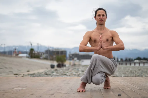 Caucasian man practices martial arts outdoors. balance and meditation