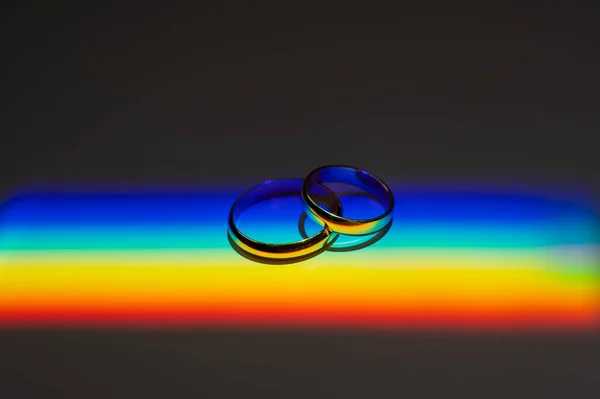 Rainbow beam on wedding rings. lgbt flag