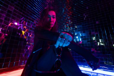 Asyalı adam güneş gözlüğü tutuyor. Neon fotoğraf stüdyosu