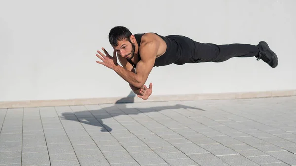 Hombre Ropa Deportiva Negra Salta Mientras Hace Flexiones Aire Libre —  Fotos de Stock