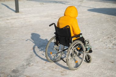 Kışın tekerlekli sandalyede oturan evsiz bir kadın.