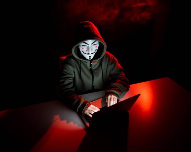 5 Haziran 2022 Novosibirsk, Rusya: Kapüşonlu Anonymous kırmızı ışıkta karanlıkta dizüstü bilgisayarda yazıyor