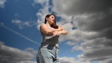 Bulutlu bir gökyüzünün arka planında dans eden beyaz bir kadın. Video 360 derece