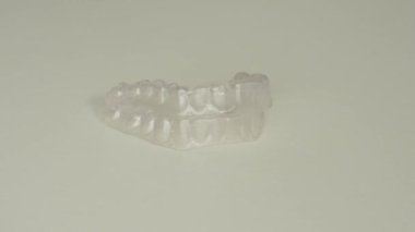 Şeffaf bir plastik hizalayıcı beyaz bir arkaplanda dönüyor