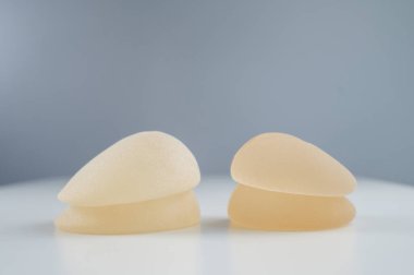 Beyaz bir masaya iki çift farklı göğüs implantı.