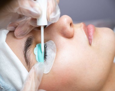 Kirpik boyama ve kaplama prosedüründen geçen genç bir kadın.