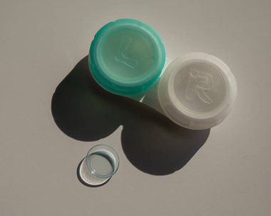 Beyaz bir masada kontak lensler ve bir depolama kabı