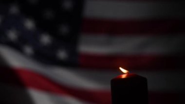Amerika Birleşik Devletleri 'nin bayrağını sallayan arka planda yanan mum.