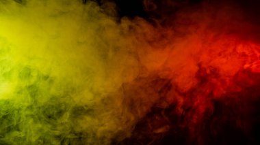 Kırmızı-sarı duman siyah arkaplanda yayılır