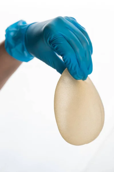 Female Hand Gloves Holds Teardrop Shaped Breast Implant White Background — Stock Photo, Image