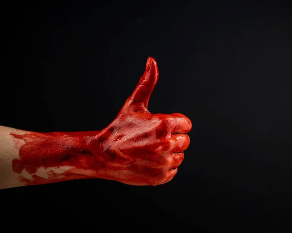 一只沾满鲜血的女人的手在黑色背景上竖起大拇指 — 图库照片