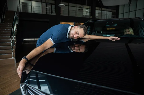 Homem Caucasiano Feliz Abraçando Capô Seu Carro Novo Uma Concessionária — Fotografia de Stock