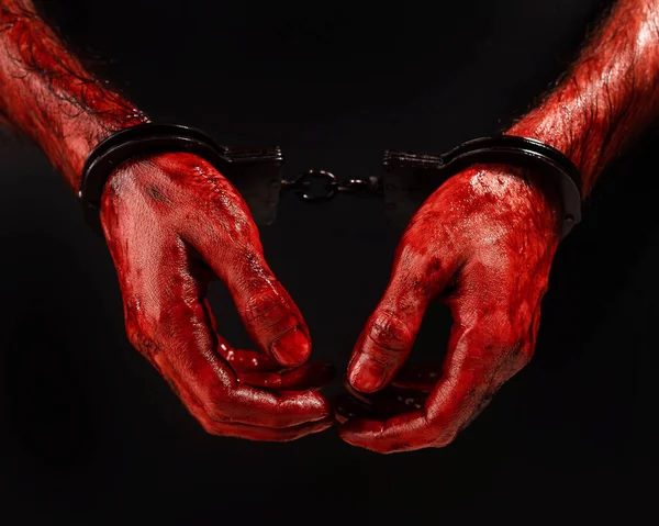 黒の背景に男の血の手錠の手のクローズアップ — ストック写真