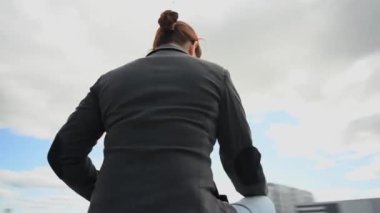 Bir iş kadını oturur, bir dizüstü bilgisayar açar ve dışarıda sevinir. Video 360 derece