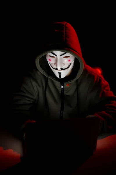 2022年6月5日俄罗斯诺沃西比尔斯克 无名氏头罩在黑暗的红灯下在笔记本电脑上打字 — 图库照片