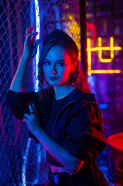 Beyaz kadın neon stüdyoda poz veriyor.