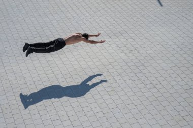 Açık havada uçan bir adam şınav çekiyor.