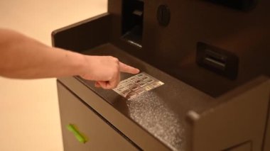 Yüzsüz kadın ATM 'de banka kartı şifresini çeviriyor.