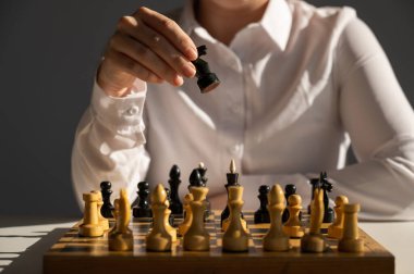 Beyaz tişörtlü, satranç oynayan yüzü olmayan beyaz kadın.
