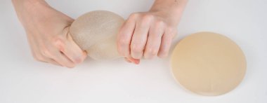 Beyaz bir kadın göğüs implantının gücünü test ediyor.